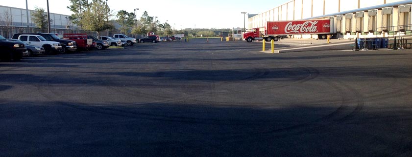 Commercial parking lot undergoing professional asphalt sealcoating in Tampa